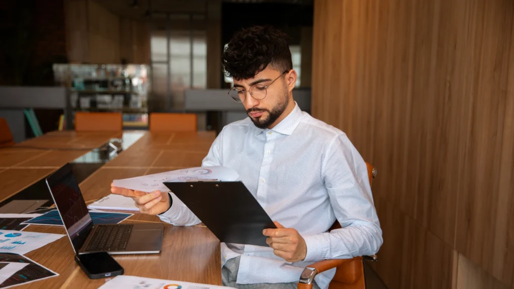 Profissional de contabilidade realizando o inventário patrimonial de equipamentos arrendados em uma empresa.